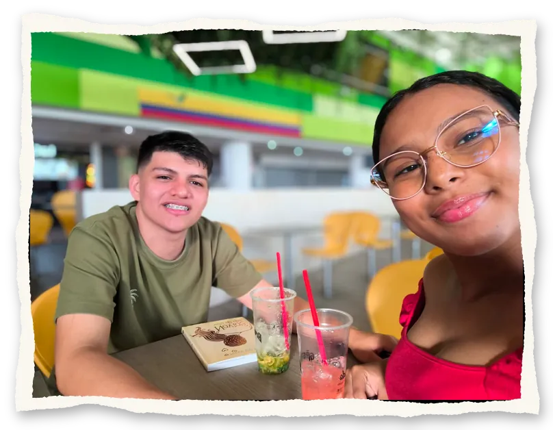 Los dos sonriendo en una mesa con sus bebidas